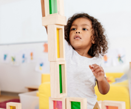 Preschool child building a tall block tower during play-based learning in a bright Willowdale classroom